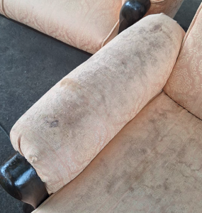 Sandaran tangan sofa dengan noda dan kotoran yang terlihat jelas sebelum dibersihkan.